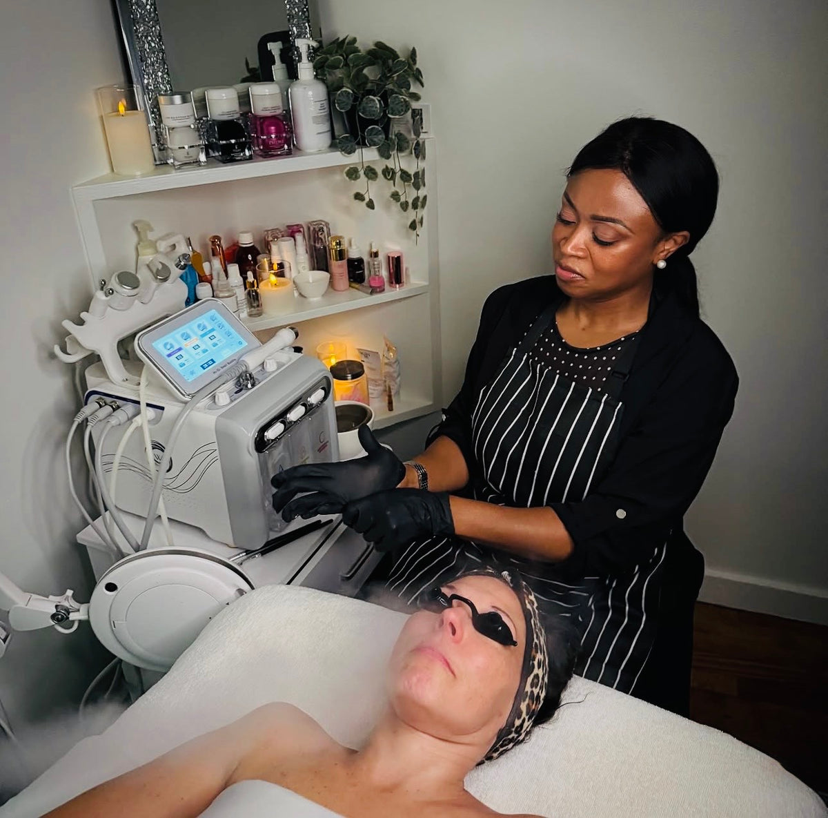 An esthetician giving a facial treatment in an Omorfia treatment room